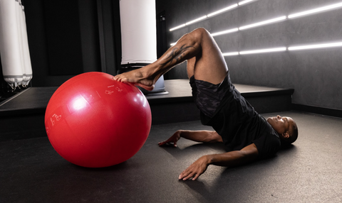 Flo Master Doing a Hamstring Curl Exercise on a Fitness Ball