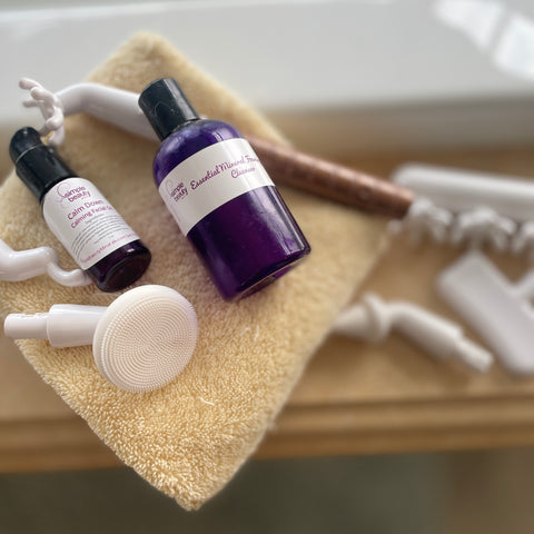 skincare bottles and devices on bath towel