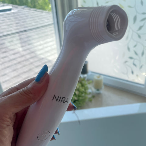 nira pro laser at home skincare device in hand in bathroom