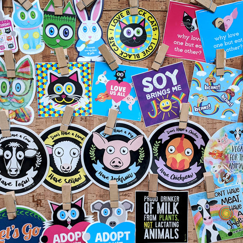 Cork board filled with colorful vinyl and bumper stickers - animal and vegan themes