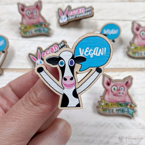 Holding Vegan! cheering cow pin