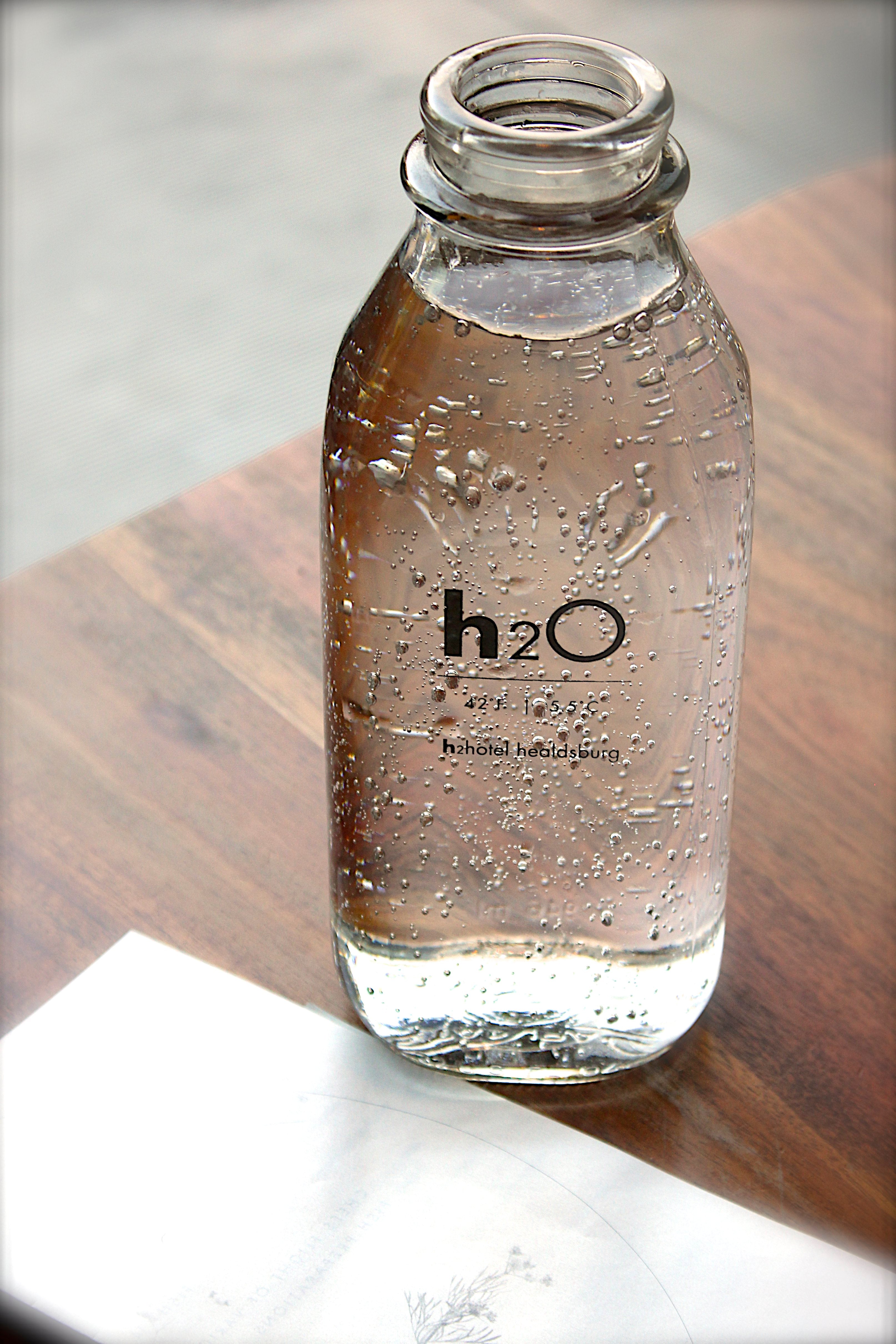 Water in glass milk bottle on desk