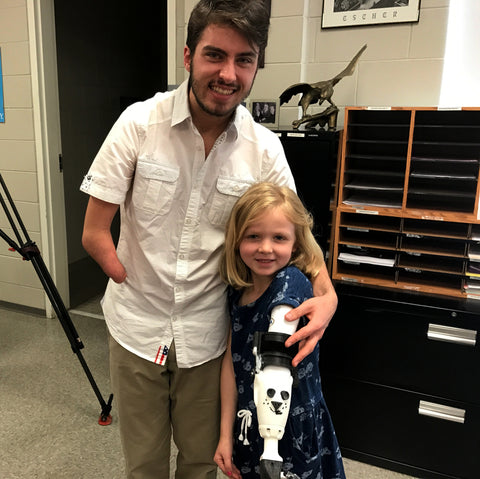 Aaron Westbrook of Form5 Prosthetics Inc. with Maddie trying a prosthetic arm