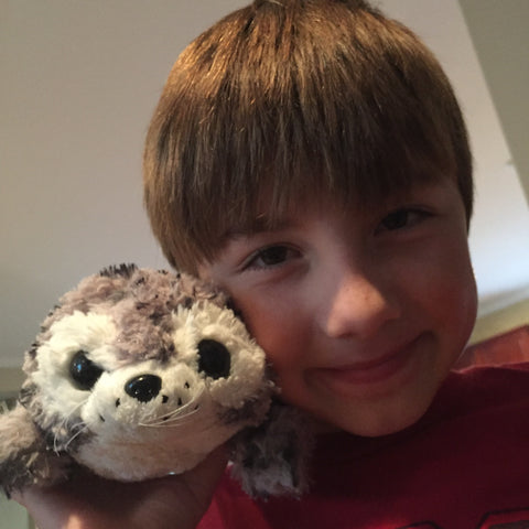 Ryan Hickman posing with Shore Buddies Sammy the Seal, made with recycled plastic bottles