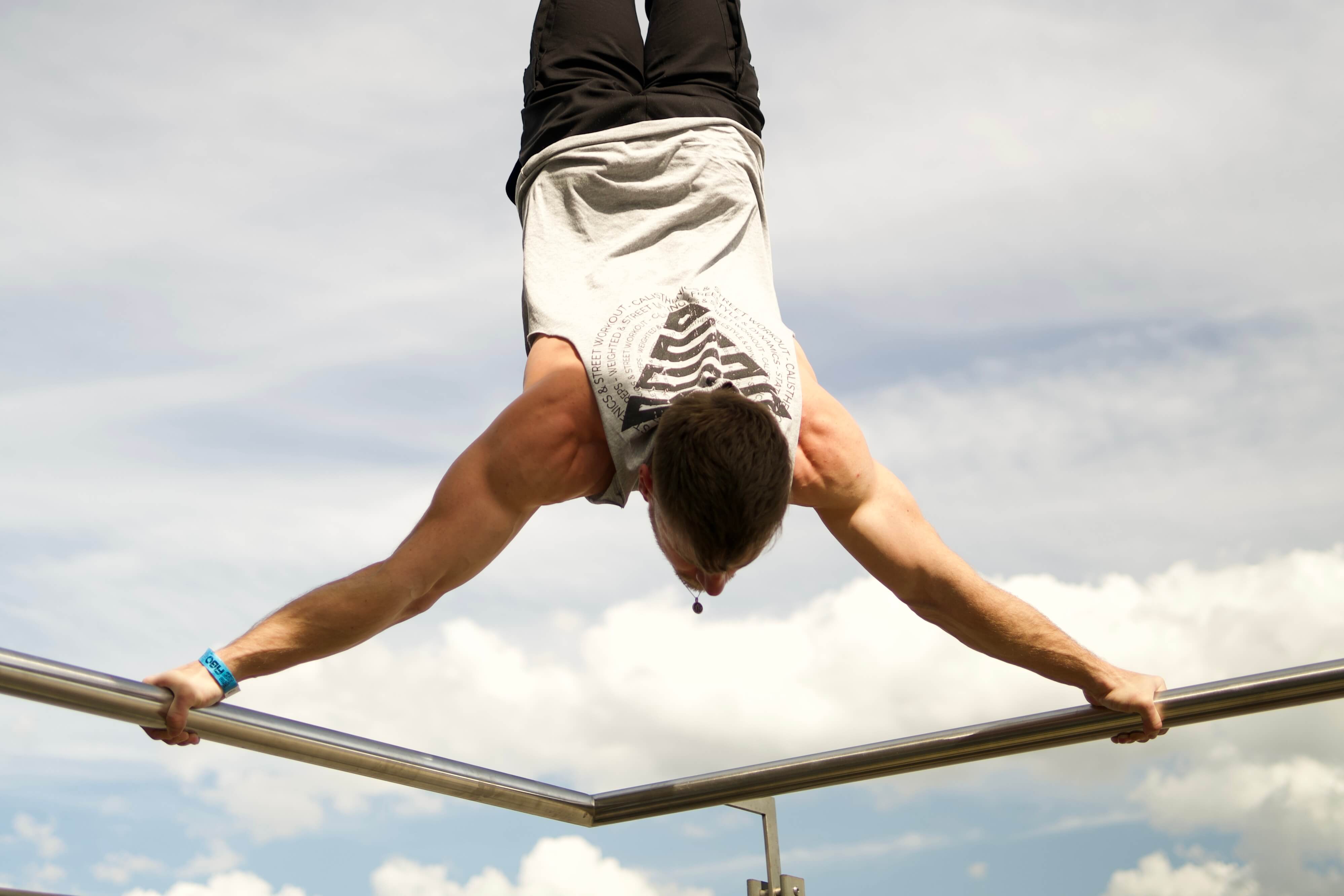 Calisthenics Athlethe wearing a GORNATION Tank Top doing a Handstand on a Bar