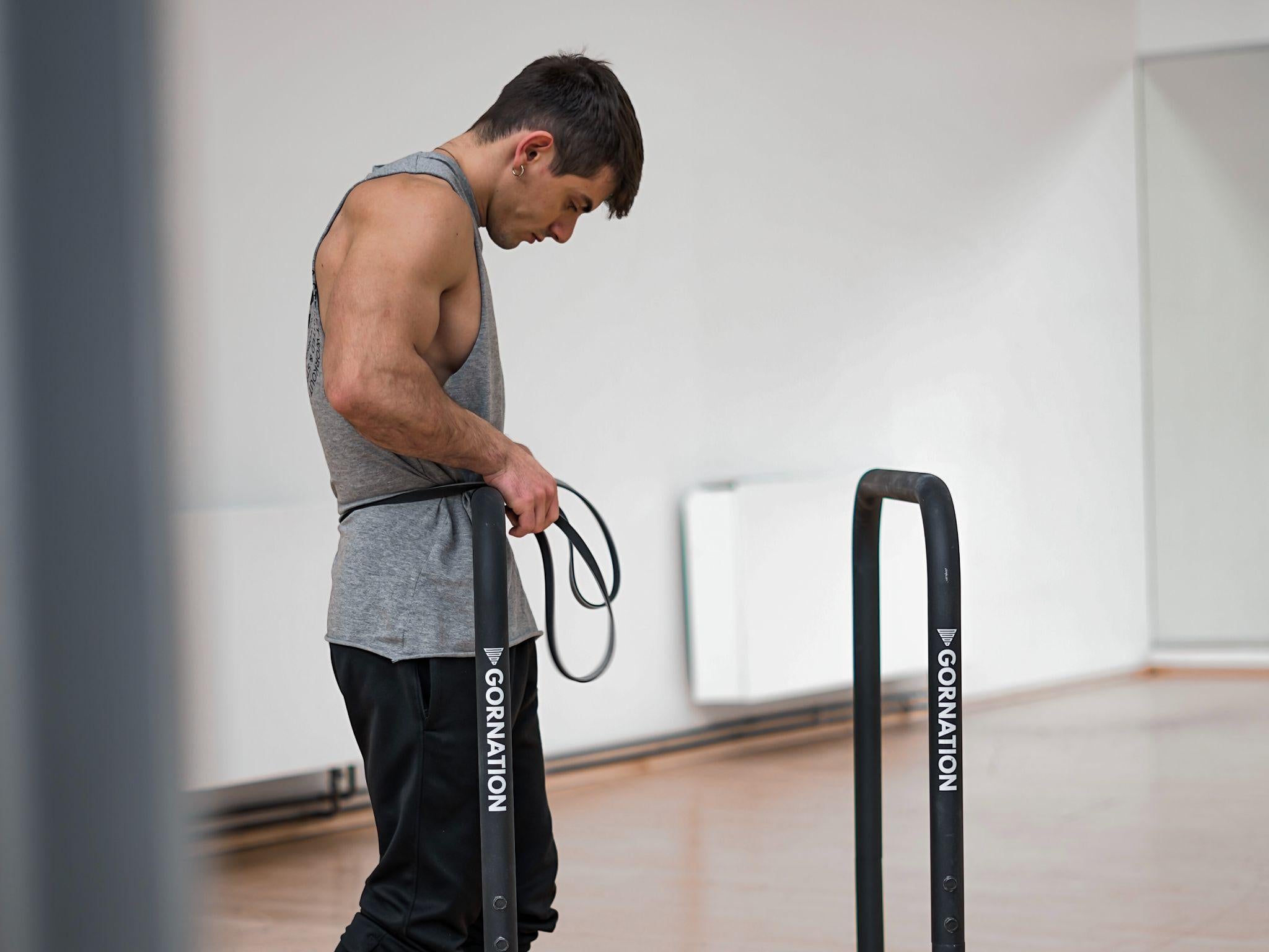 calisthenics athlete scarxlus standing next to dip bars by gornation