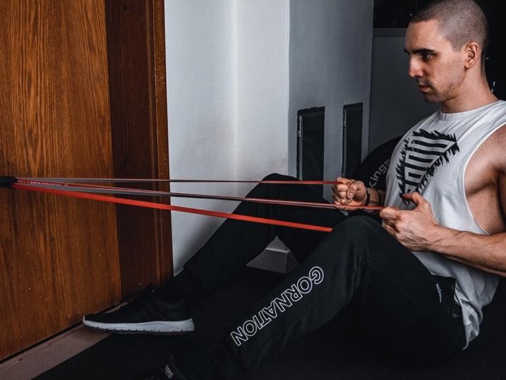 calisthenics athlete using door anchor by gornation while exercising with resistance bands