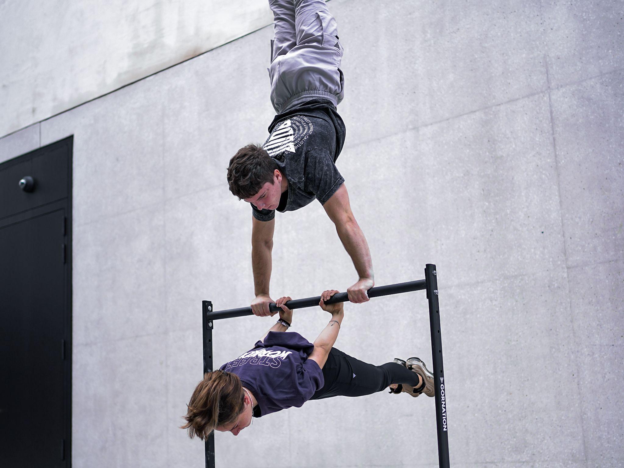 calisthenics athletes doing street workout handstand and back lever using static bar by gornation