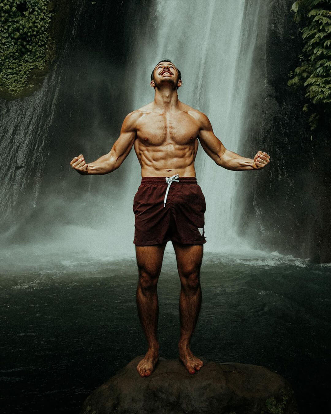 calisthenics athlete flomarrec posing in front of a waterfall