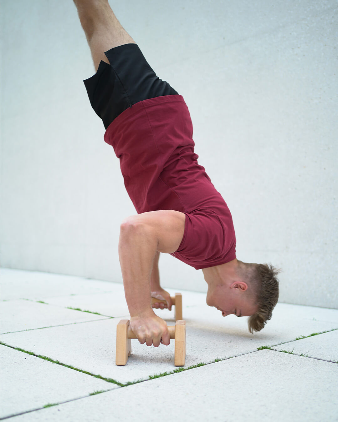 handstand push up on wooden parallettes by a male athlete