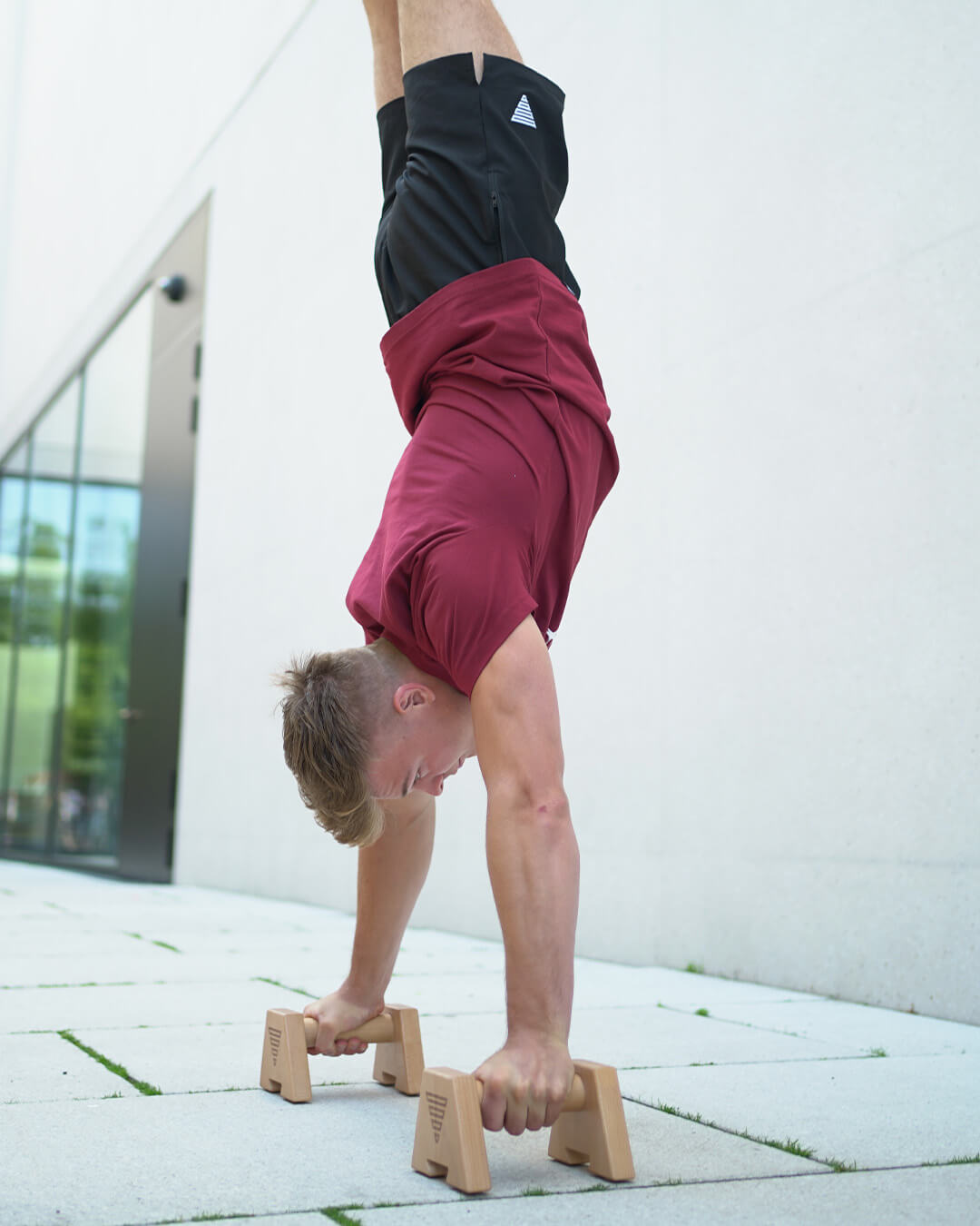 handstand position on wooden parallettes performed by an athlete