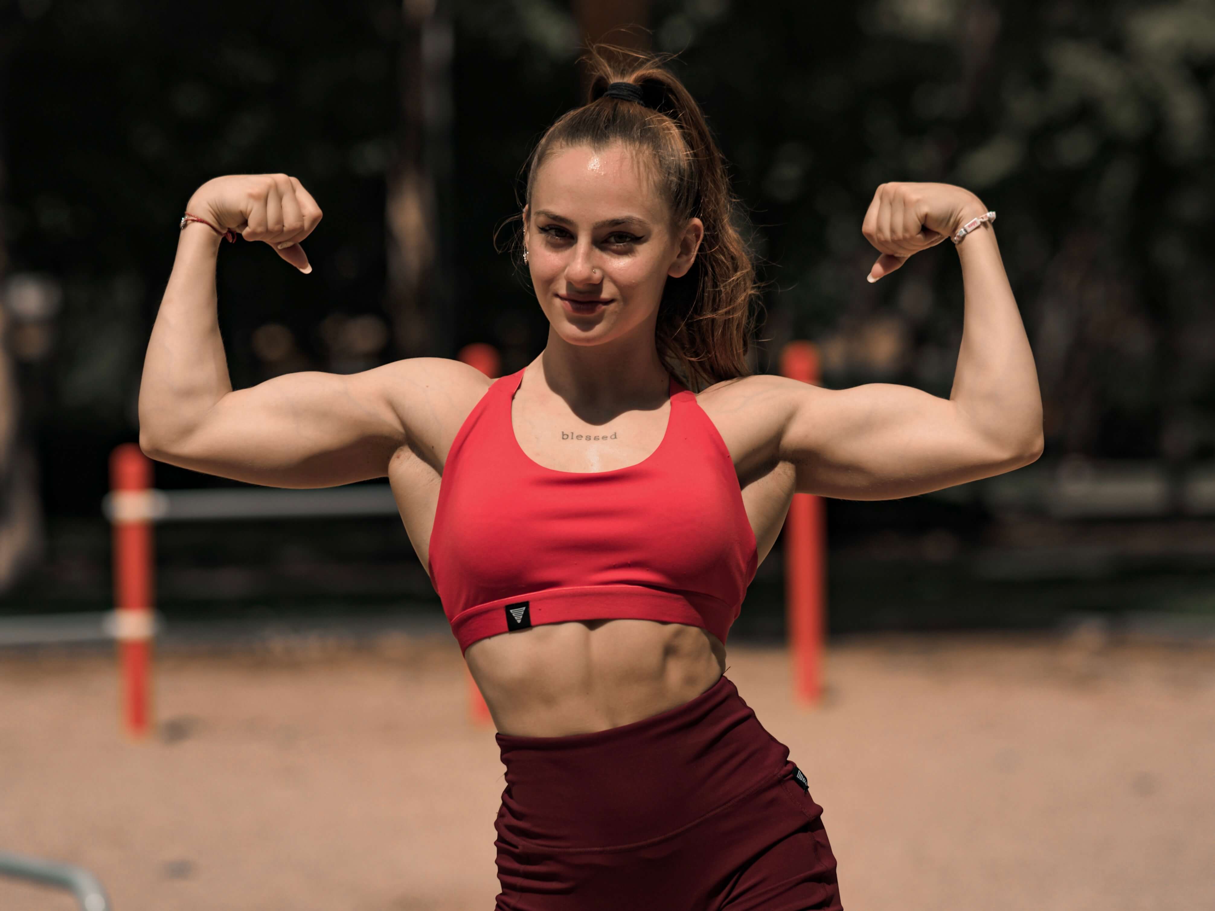 jasmina svilenova the strongest bulgarian calisthenics female athlete flexing her mucsles while wearing clothing by gornation