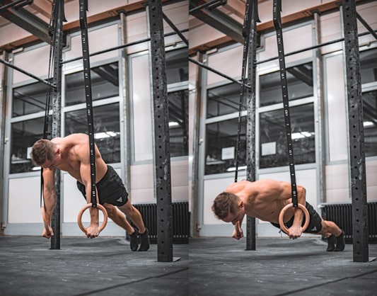 athlete does push up exercises on rings in a gym