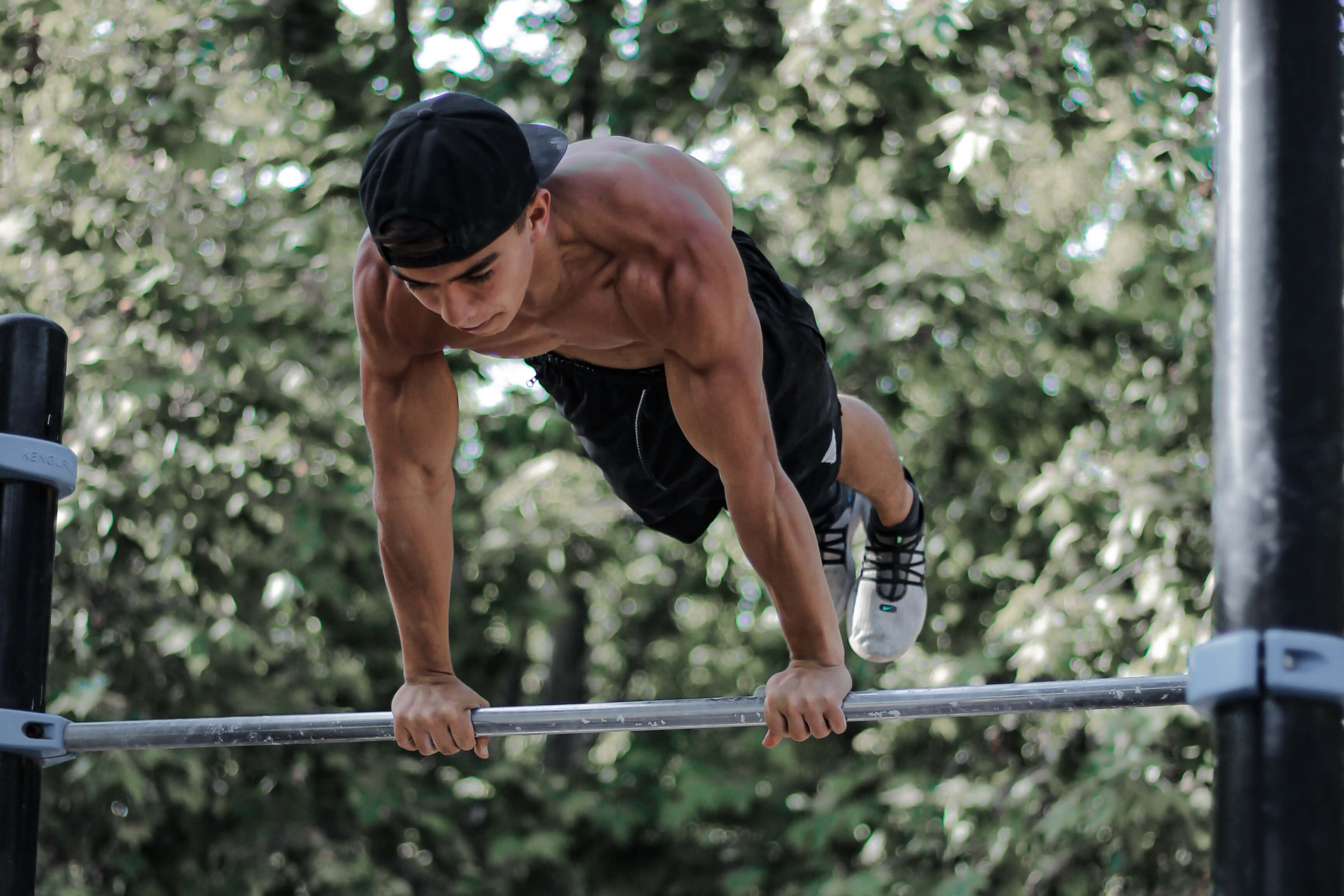 street workout athlete tony gaste doing planche on calisthenics bar