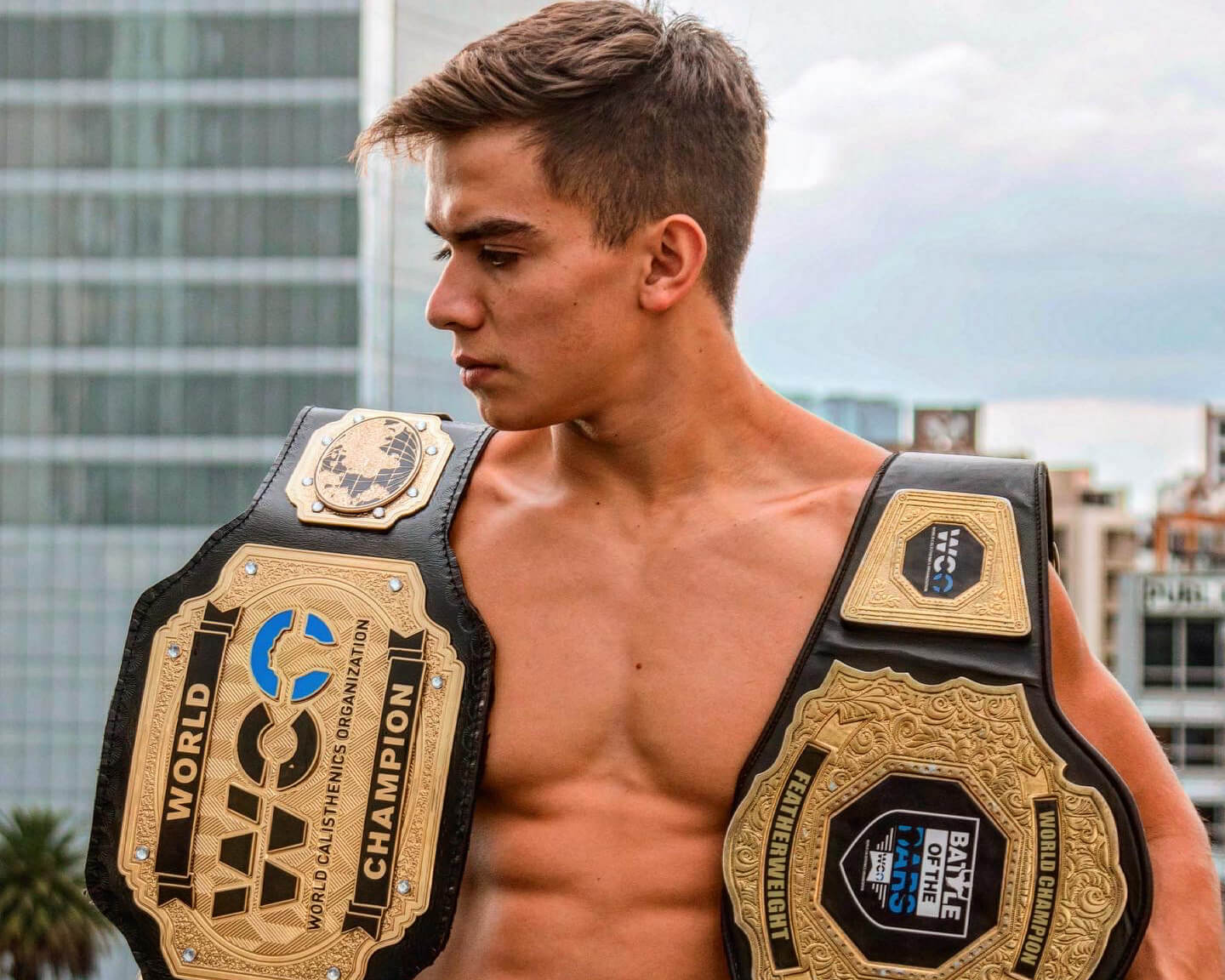 calisthenics athlete tony gaste wearing two calisthenics competition world cup champion belts