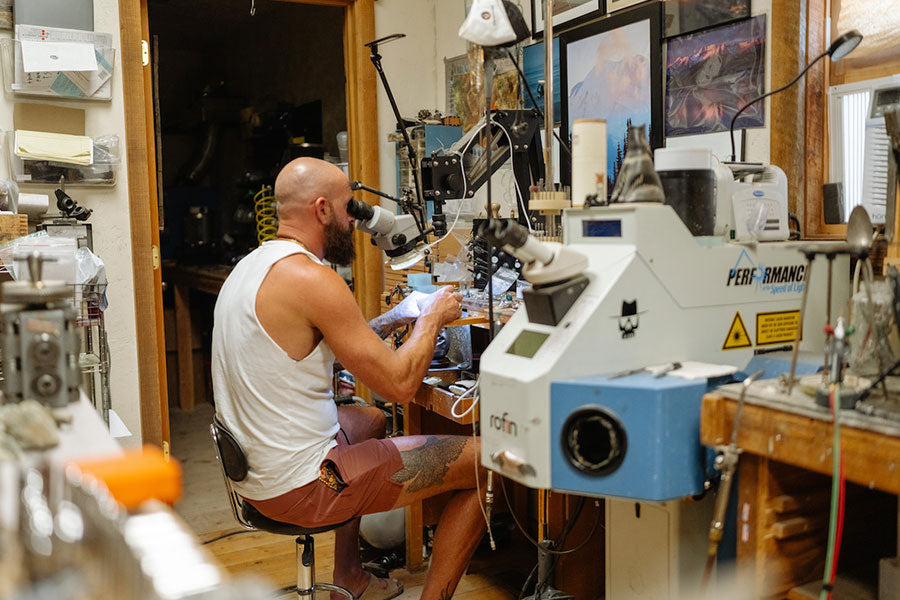 man inspecting the quality of metal in a jewlery workshop in walter sky clothing