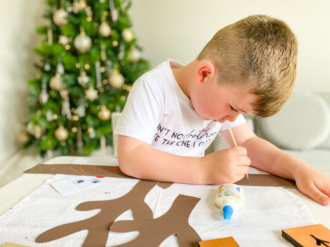 little boy doing reindeer scratch art