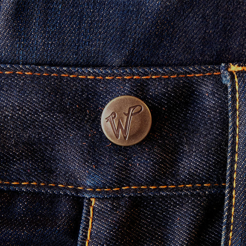 close up of hammer on button on jeans