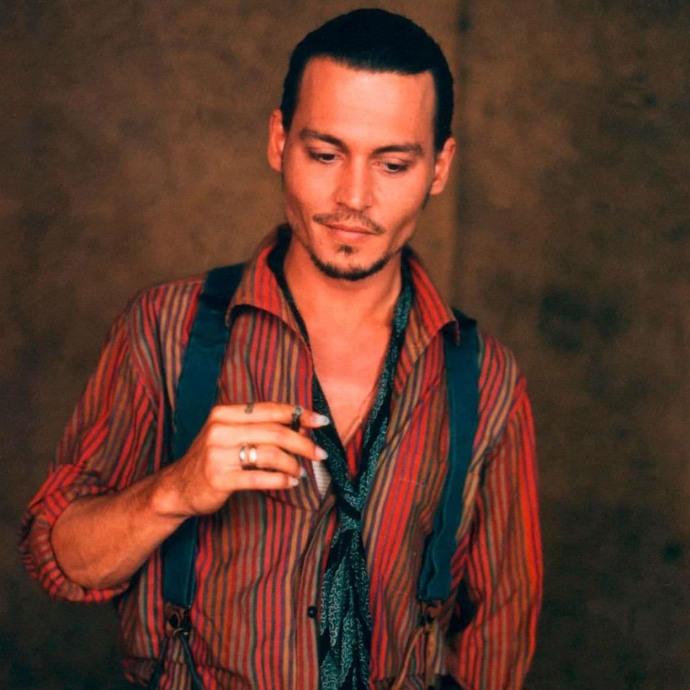 Johnny Depp as Roux in Chocolat, wearing a striped blouse, neck tie and navy blue Suspenders