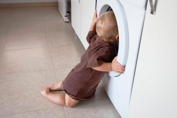 Baby looking into the washing machine