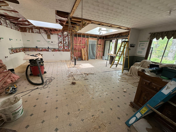 image of kitchen under construction, ceiling torn out , wall exposed insulation and no furniture in the space