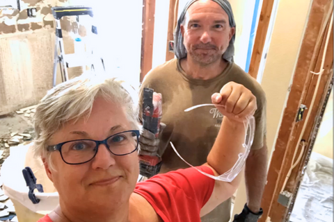 two people posing after doing demolition in their kitchen remodel