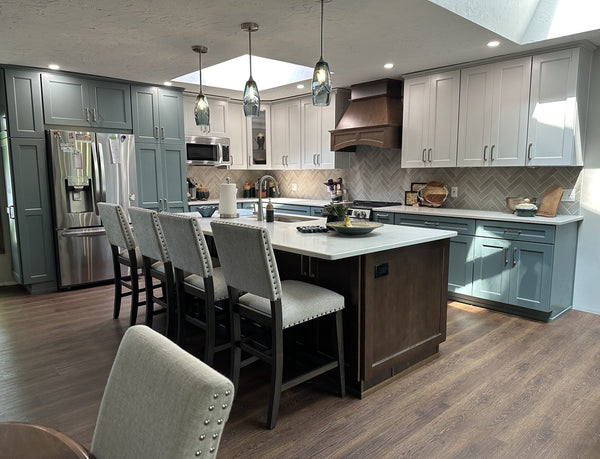 image of blue and gray modern style kitchen with large wooden kitchen island and three glass pendants above the island