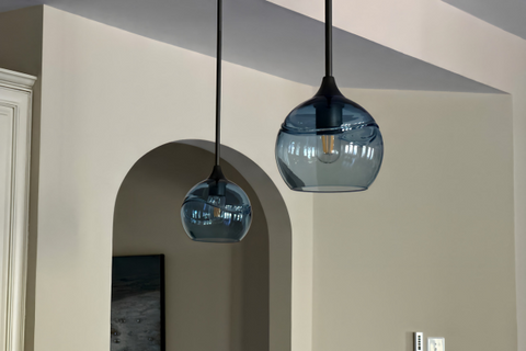 image of two blue glass globe pendants hanging from a ceiling in a hallway