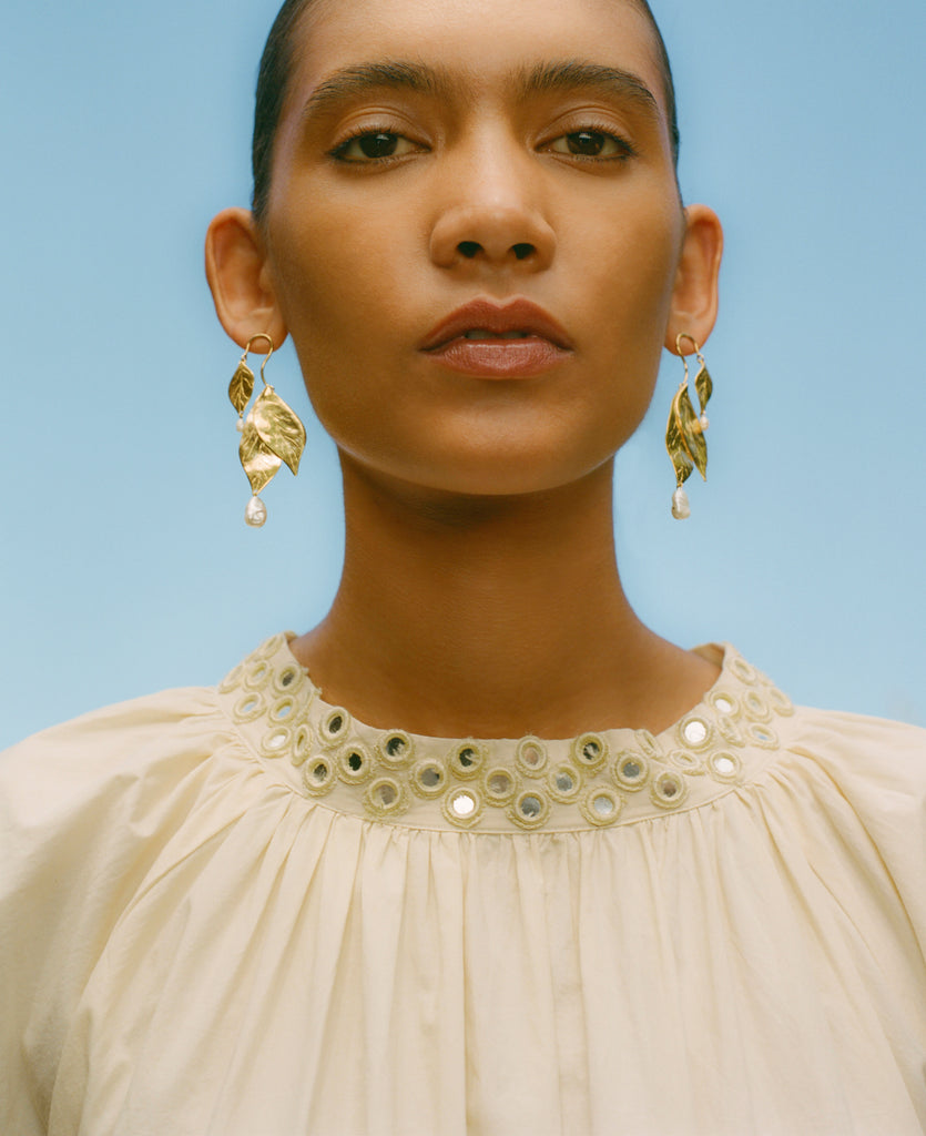 Model wearing gold earrings