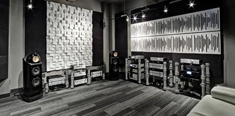 Black and white picture of Bowers & Wilkins speakers next to acoustic panels 