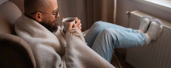 Man warms himself by heater