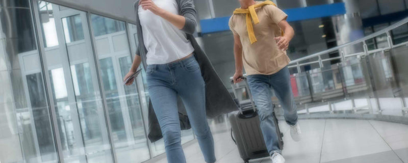 Couple sprinting through airport terminal