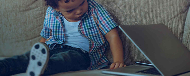 Child peeking at laptop computer