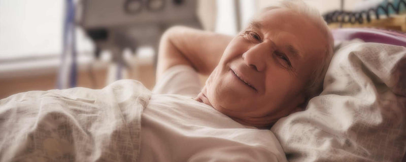 Elderly man laying in hospital bed