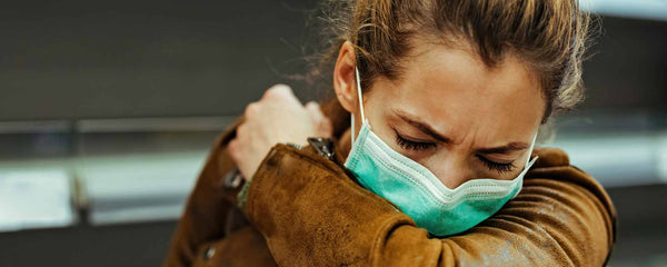 Female coughing into her sleeve