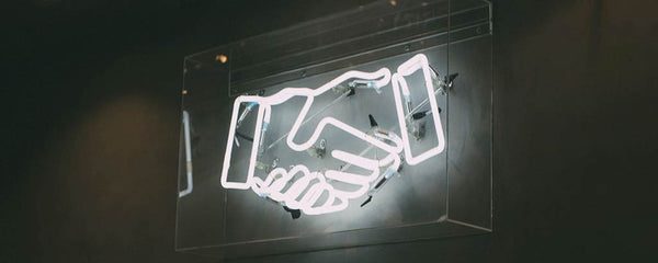 Neon sign depicting a handshake
