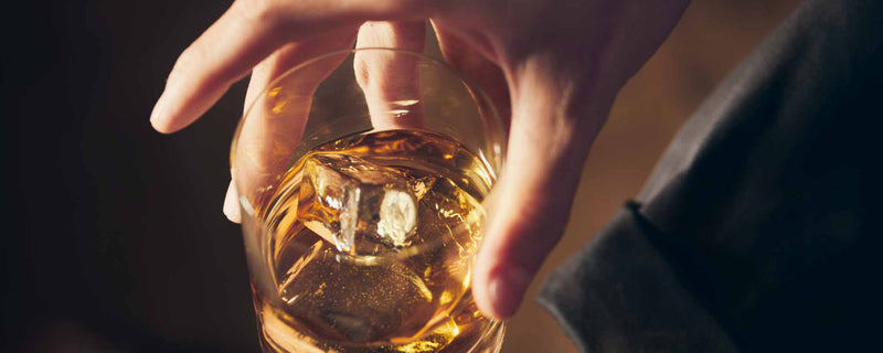 Hand holding whiskey glass
