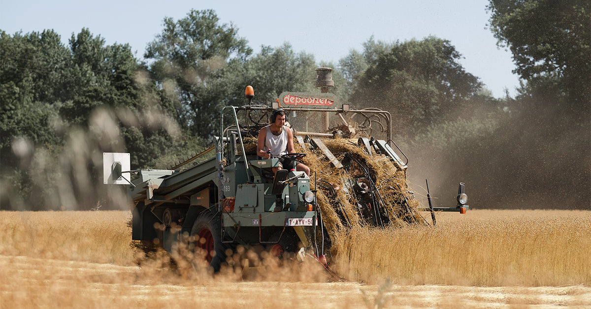 A farmer on a tractor harvesting flax, used to make linen for Community Clothing garments.