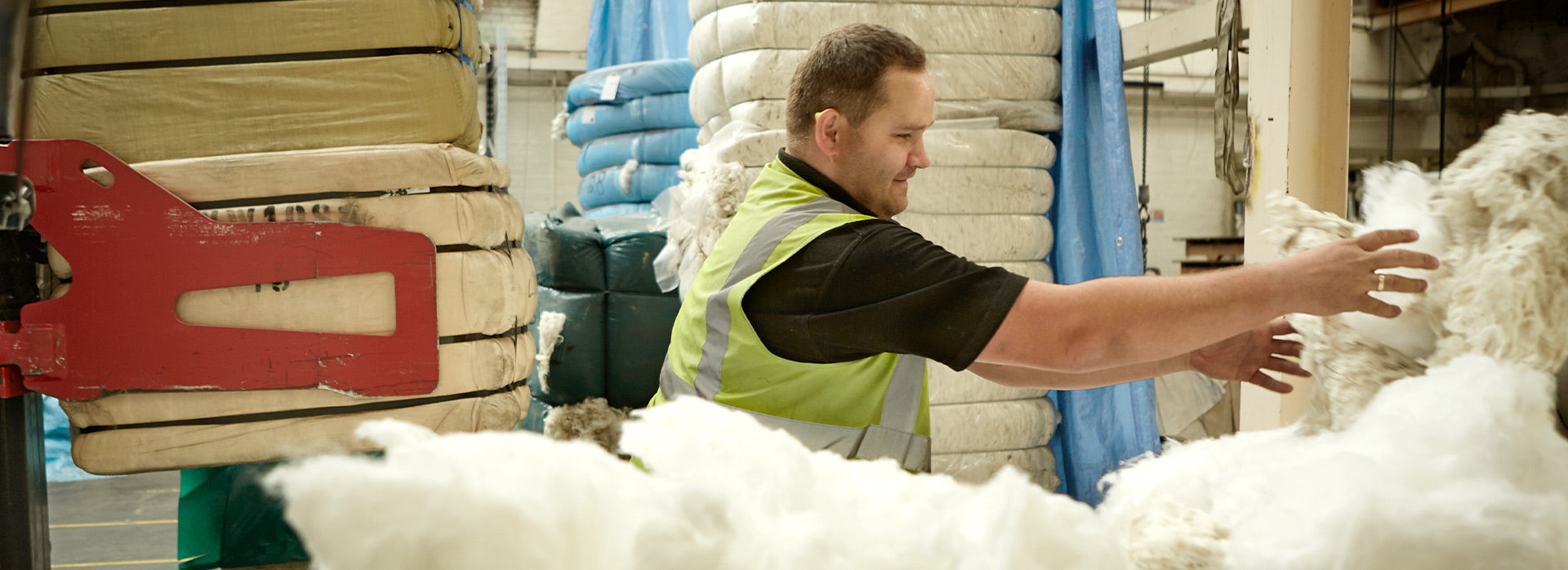 A male factory worker taking a delivery of raw merino wool, used to make Community Clothing pure peacoats.