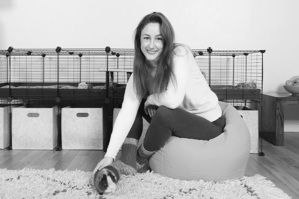 When Kavee CEO Clementine couldn't find suitable cages for her guinea pigs, she made her own. Pictured is Clementine sitting next to her guinea pig in front of a C&C cage.