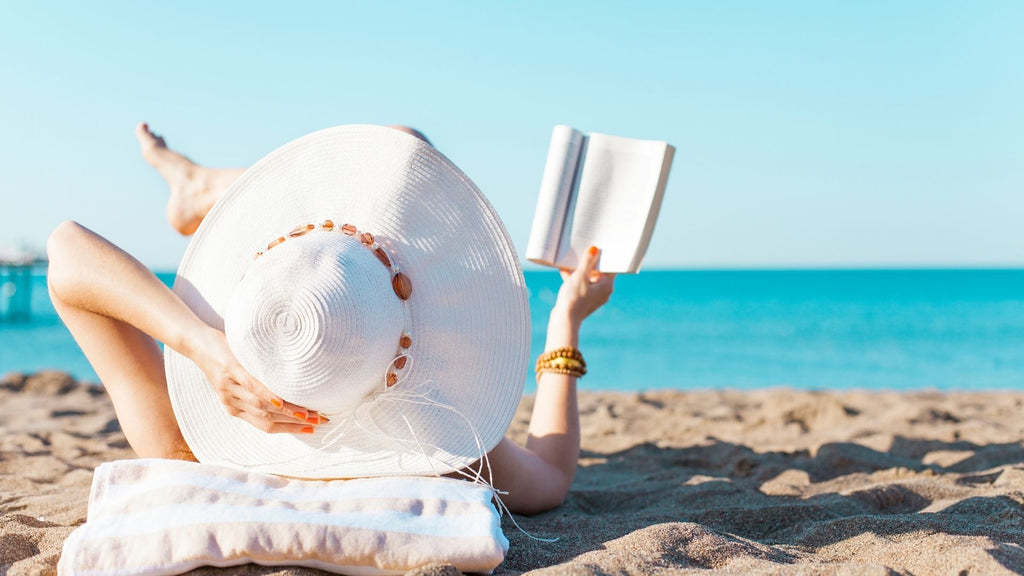 What reasons can you board your guinea pigs? woman sunbathing and reading a book on a sandy beach