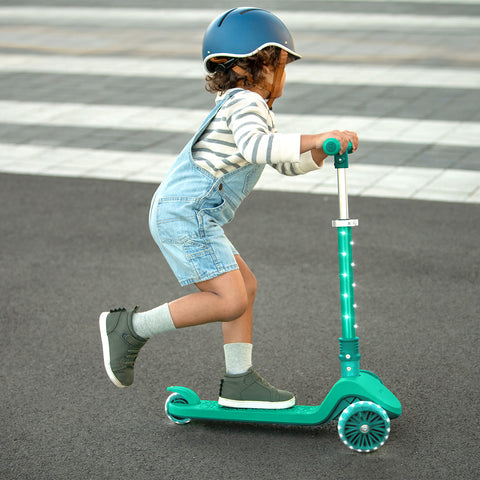 young kid riding a three wheel kick scooter
