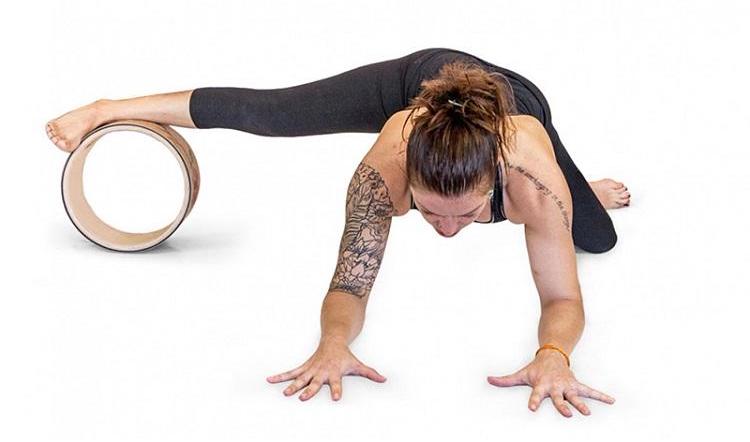 une femme utilise la roue de Yoga luxe sous le pied