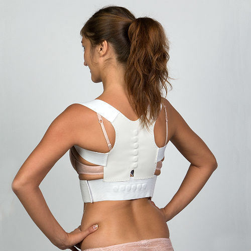 Une femme porte un corset correcteur de posture magnétique noir pour corriger ses problèmes de scoliose, cyphose, stenose.