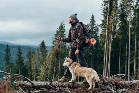 A man in the cold wilderness with his dog