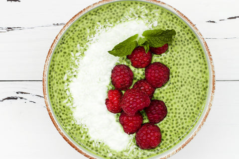 Matcha chia pudding topped with bright red raspberries as an example of how to use matcha tea