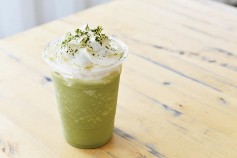 A frothy, matcha latte with whipped cream on top as an example of how to use matcha tea