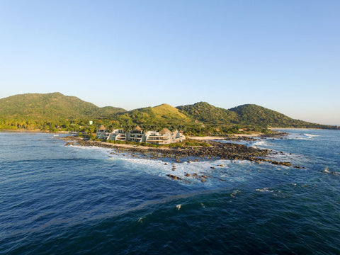 Turismo wellness en el paraíso guerrerense de Troncones     ·         Si lo que buscas es un espacio para relajarte y encontrar armonía y paz, Troncones es el destino ideal.     De la mano de Club Premier, Ana Paula Domínguez, fundadora del Instituto Mexicano de Yoga y promotora del bienestar, te cuenta cómo hacer un viaje de wellness en el paraíso guerrerense de Troncones.     Creo que una de las cosas que nos enseñó la pandemia fue replantearnos la forma de viajar, buscar rincones en el mundo menos poblados, más vírgenes y naturales. Al inicio de la pandemia, ansiosa, pensando en escenarios catastróficos urbanos, empaqué y junto con mi hijo y nuestra perrita nos fuimos en dos ocasiones en coche a Troncones, durante 2020 y 2021.     Por la seguridad y los hermosos paisajes, sobre todo en el tramo de Pátzcuaro hacia el destino final, el recorrido vía Morelia-Lázaro Cárdenas es una opción idónea para quien viaja desde la Ciudad de México y su área metropolitana. Troncones está ubicado a 35 km al norte de Zihuatanejo y se caracteriza por ser una de las opciones preferidas para los aficionados y profesionales del surf, aunque también para los amantes del yoga y la vida simple. Cerca de la naturaleza y lejos del celular, la experiencia en esta playa puede llenarte de armonía.     DÓNDE DORMIR  Antes que nada debes pensar en dónde hospedarte. Un buen viaje de wellness empieza por un lugar hermoso donde haya oportunidades para comer bien, practicar yoga y meditación, y encontrar momentos de paz en la naturaleza.  ·         HOTEL LO SERENO  Sin duda, la opción más exclusiva para hospedarse, aunque es también la más costosa. Cuenta con diez suites de lujo y un restaurante gourmet en donde cocinan con productos locales. Las habitaciones son de diseño contemporáneo y moderno, cada una cuenta con una terraza con puertas corredizas de madera y baños encapsulados en cristal que son verdaderamente mágicos. El restaurante tiene vista al mar, una galería y un área lounge.  ·         PRESENT MOMENT RETREAT  Es una opción con cabañitas que cuentan con aire acondicionado, sala de yoga al aire libre y vista al mar. Suelen hacer retiros, pero cuando no hay eventos, las cabañas están abiertas al público en general y ofrecen clases de yoga y meditación todos los días. La vista al mar es increíble y ofrecen varias opciones veganas en su restaurante.  ·         HACIENDA EDÉN  Es otro hotel frente a playa Manzanillo, tiene un restaurante con comida mexicana contemporánea. La alberca se confunde con la bahía, que es casi virgen e ideal para familias.  ·         PUNTA MAJAHUA  “Es un desarrollo de Zozaya Arquitectos al norte de Troncones, exclusivo y fantástico. Este lugar tiene las mejores vistas, una playa casi virgen y muy privada, y a tan sólo 100 metros está Martha’s, un sencillo restaurante en donde podrás comer la pesca del día a precios únicos”.     ·         CASA TRIÁNGULO LA SALADITA  Playa La Saladita es el punto de reunión de los surfers y esta casa que puedes rentar en Airbnb está tan sólo a 5 minutos caminando. Esta playa semivirgen tiene tanto las mejores olas para surfear como una bahía muy apta para familias con hijos pequeños.     PARA SALIR  El wellness y la diversión no están peleados, por eso, AMOR TROPICAL es una parada imperdible en un viaje a Troncones. Es un bar en la playa que además de ser cómodo, tiene comida deliciosa, una gran diversidad de coctelería y distintos DJs.     PARA COMER  Para desayunar, INDIGO es una gran opción, ya que serás atendido por sus dueños, originarios de Argentina. Este lugar tiene opciones vegetarianas y veganas, pero los amantes de la carne también tendrán opciones deliciosas. No te vayas sin probar algo de su panadería.  CAFÉ CORAZÓN es otro de mis favoritos. Tiene un menú plant-based, su café es inigualable y ahí encontrarás smoothies y jugos recién hechos.  CAFÉ PACÍFICO es otro de los lugares que recomiendo mucho. Sus precios son accesibles y encontrarás buenas opciones para desayunar y comer.     DÓNDE COMPRAR (COSAS LINDAS)  Si quieres llevar a casa algún recuerdo, no dejes de visitar CASA CROMA. Tiene las mejores y más finas artesanías de distintos lugares de México, admirable selección de su dueña Mariana.      Si estás considerando hacer un viaje wellness, visita el blog Viajero Premier para encontrar más destinos apasionantes, y recuerda acumular Puntos Premier en todos tus viajes.