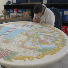 Artist painting a volcanic stone table at CeramicArte factory