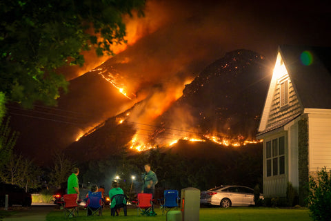 Firefighters protecting a house from wildfire